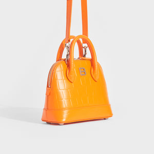 Side view of Balenciaga XXS ville embossed leather tote in orange