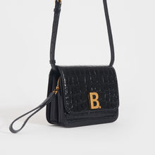 Load image into Gallery viewer, Side view of the BALENCIAGA B Small Embossed Crossbody Bag in Black