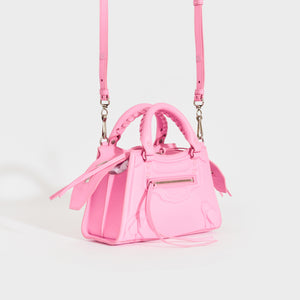 Side view of the BALENCIAGA Mini Neo Classic City Leather Bag in Rose with crossbody strap