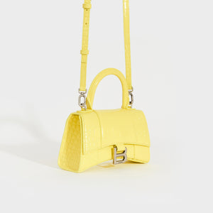 Side view of the BALENCIAGA XS Hourglass Top Handle Bag in Light Yellow Embossed Croc