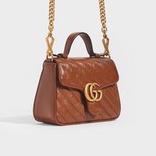 Load image into Gallery viewer, Side view of Gucci GG Marmont Mini Top Handle Bag in Brown Quilted Leather with gold chain strap