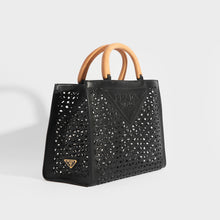 Load image into Gallery viewer, Side view of the PRADA Leather Cut Out Shopper with Wooden Handles in Black