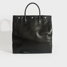 Load image into Gallery viewer, Back view of Saint Laurent Rive Gauche tote bag in black leather and silver hardware