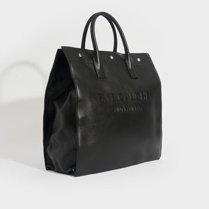 Side view of the SAINT LAURENT Rive Gauche Tote Bag in Black Leather