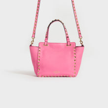 Load image into Gallery viewer, Rear view of the VALENTINO Garavani Mini Rockstud Leather Tote Bag in Dawn Pink