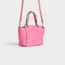 Load image into Gallery viewer, Side view of the VALENTINO Garavani Mini Rockstud Leather Tote Bag in Dawn Pink
