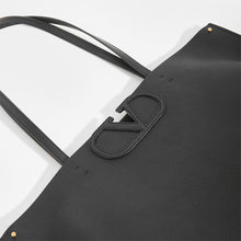 Load image into Gallery viewer, Detail of V logo on VALENTINO Garavani Fill Me Tote in Black Leather