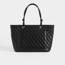 Load image into Gallery viewer, Rear view of the CHANEL Vintage Cambon Ligne Tote in Black Leather with outside pocket