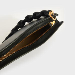 Inside shot of Jacquemus La Vague shoulder bag in black leather and canvas lining.