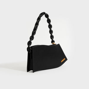 Side view of Jacquemus La Vague in black leather with gold hardware