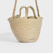 Load image into Gallery viewer, Side view of Balenciaga Ibiza nylon and leather basket bag in beige