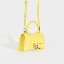 Load image into Gallery viewer, Side view of the BALENCIAGA XS Hourglass Top Handle Bag in Light Yellow Embossed Croc