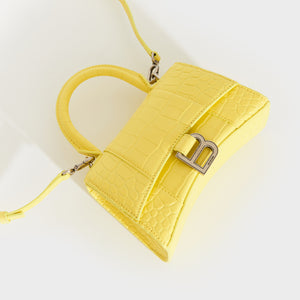 Top down detail of the BALENCIAGA XS Hourglass Top Handle Bag in Light Yellow Embossed Croc