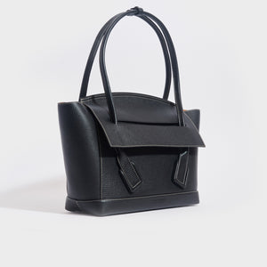 Side view of the BOTTEGA VENETA Arco Large Grained Leather Tote in Black with Gold Hardware