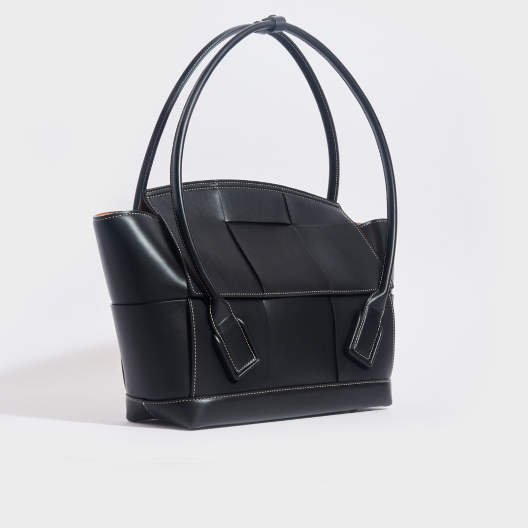 Side view of the BOTTEGA VENETA Arco Large Intreccio Leather Tote Bag in Black