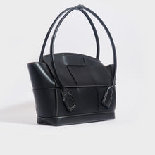 Load image into Gallery viewer, Side view of the BOTTEGA VENETA Arco Large Intreccio Leather Tote Bag in Black