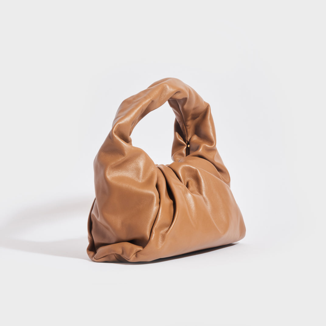 Side view of the BOTTEGA VENETA Medium Shoulder Pouch Leather Bag in Camel