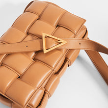 Load image into Gallery viewer, Top view of BOTTEGA VENETA Padded Cassette Crossbody Bag in Caramel Lambskin Leather