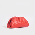 Side view of the BOTTEGA VENETA The Pouch Intrecciato Leather Clutch in Red