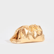 Load image into Gallery viewer, Side view of the BOTTEGA VENETA The Pouch Leather Clutch in Gold