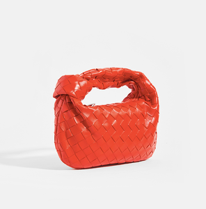 Side view of the BOTTEGA VENETA Mini Jodie Intrecciato Leather Top Handle Bag in Red