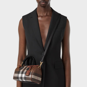 Model wearing the BURBERRY Check and Leather Mini Bowling Bag in Dark Birch Brown
