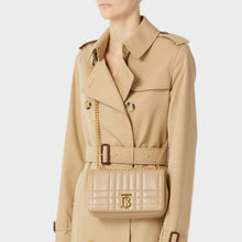 Load image into Gallery viewer, Model wearing a Burberry trench and the BURBERRY Small Quilted Lola Bag in Oat Beige