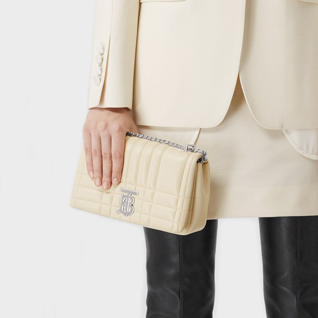 Model holding the BURBERRY Small Quilted Lola Bag in Pale Vanilla
