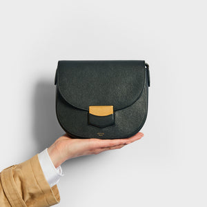 Model holding the CELINE Small Trotteur Bag in Black