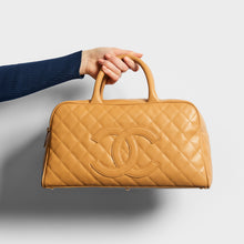 Load image into Gallery viewer, Model holding the CHANEL CC Quilted Caviar Bowling Bag in Beige 2003 - 2004