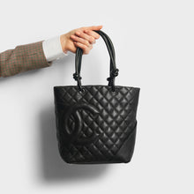 Load image into Gallery viewer, Hand holding Chanel cambon ligne diamond quilted tote back in black from 2003-2004