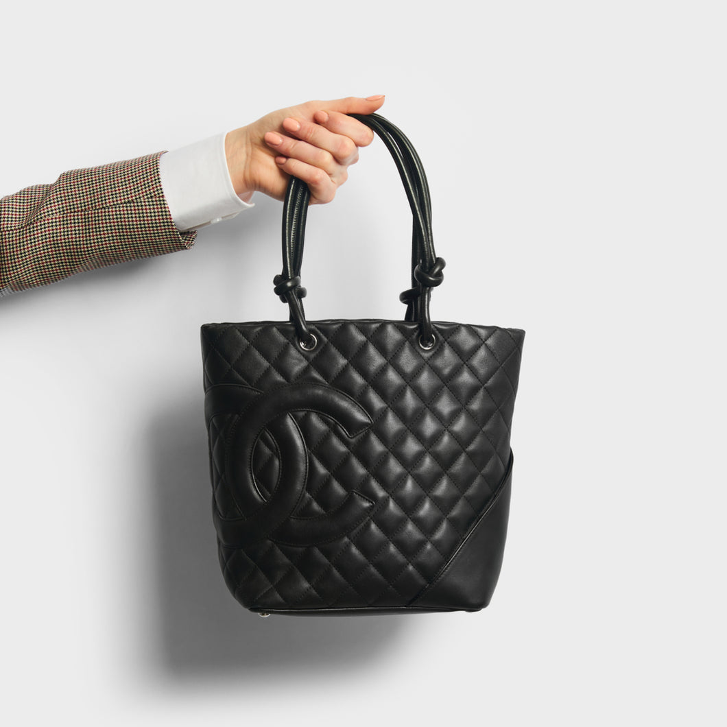 Hand holding Chanel cambon ligne diamond quilted tote back in black from 2003-2004