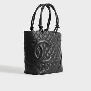 Side view of Chanel cambon ligne diamond quilted tote bag in black leather from 2003-2004