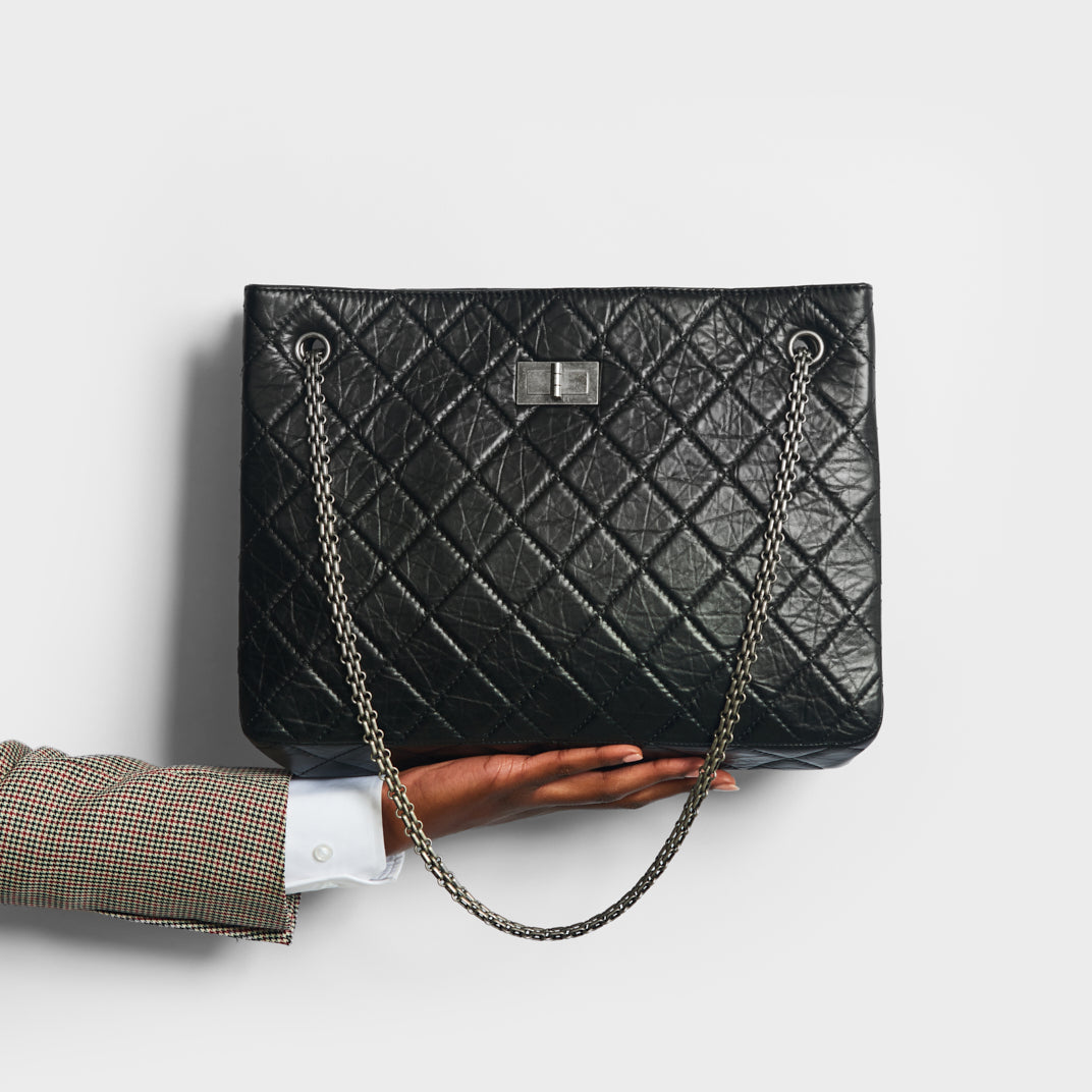 Model holding CHANEL Reissue 2.55 Computer Laptop Work Business Classic Tote Bag in Black Aged Calfskin 2015-2016