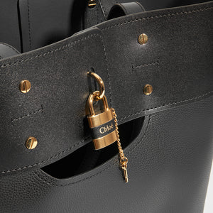 Lock detail on CHLOÉ Aby Large Smooth and Grained Leather Tote in Black