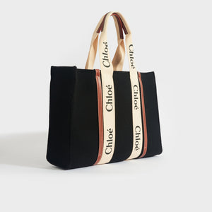 Side view of Chloe large woody tote in black felt with tan leather detailing