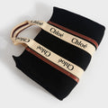 Flat shot of Chloe large woody tote in black felt with tan leather detailing