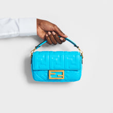 Load image into Gallery viewer, Model holding the FENDI Mini Baguette Bag in Turquoise Embossed Leather