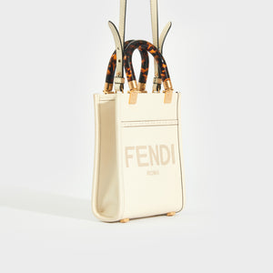 Side view of the. FENDI Sunshine Mini Shopper Bag in Ivory