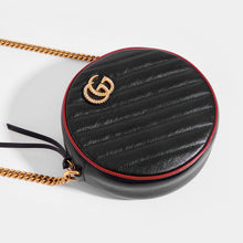 Load image into Gallery viewer, Close up of Gucci GG Marmont Mini Round Shouder Bag in Black Leather with Red Trim and Gold chain strap
