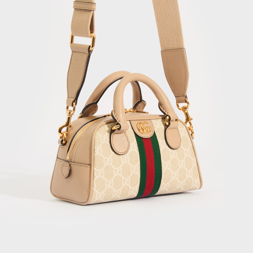 Side view of the GUCCI Ophidia Mini GG Top Handle Bag in Beige and White GG Supreme Canvas with strap 