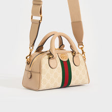 Load image into Gallery viewer, Side view of the GUCCI Ophidia Mini GG Top Handle Bag in Beige and White GG Supreme Canvas with strap 