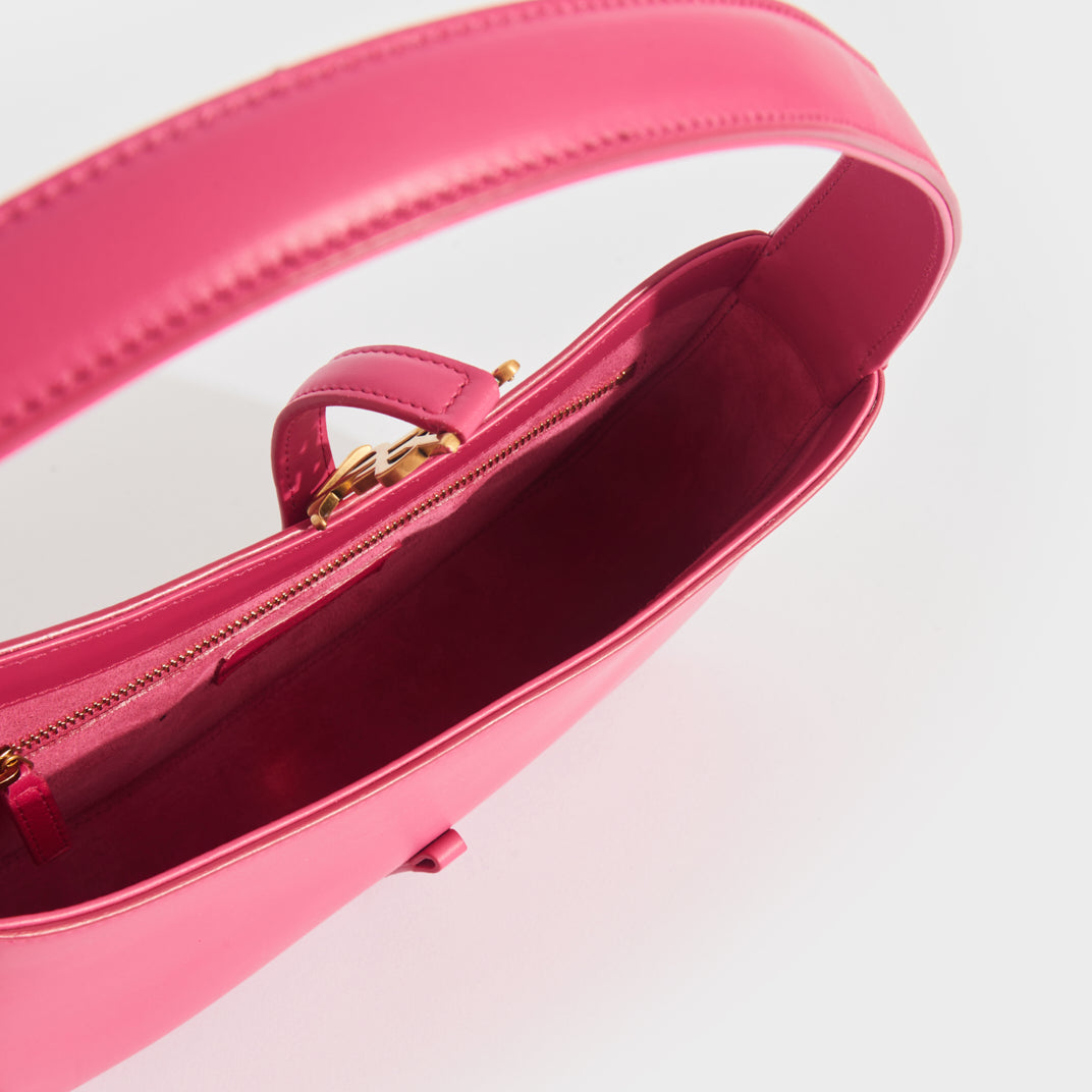 Inside shot of Saint Laurent Le 5 a 7 leather hand bag in bubblegum pink. Bubblegum pink suede lining with gold hardware