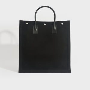 Back view of Saint Laurent Rive Gauche tote back in black canvas and black leather handles