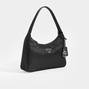 Side view of Prada Hobo Re-Edition 2000 Nylon bag in black and tag