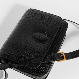 Top down detail view of the SAINT LAURENT Le 61 Framed Small Saddle Bag in Mock-Croc Leather in Black